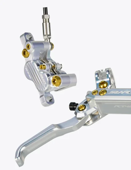 Primer plano de los Frenos SUHR en color plata con tornillos de titanio en color dorado