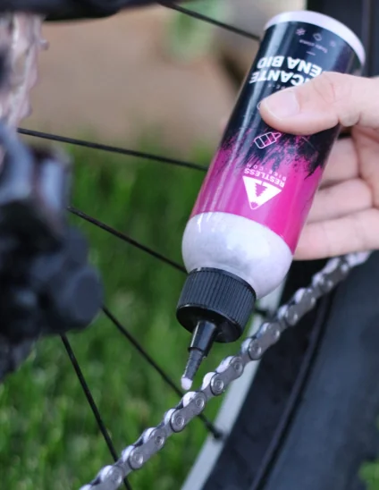 aplicando la cera en la cadena de la bicicleta